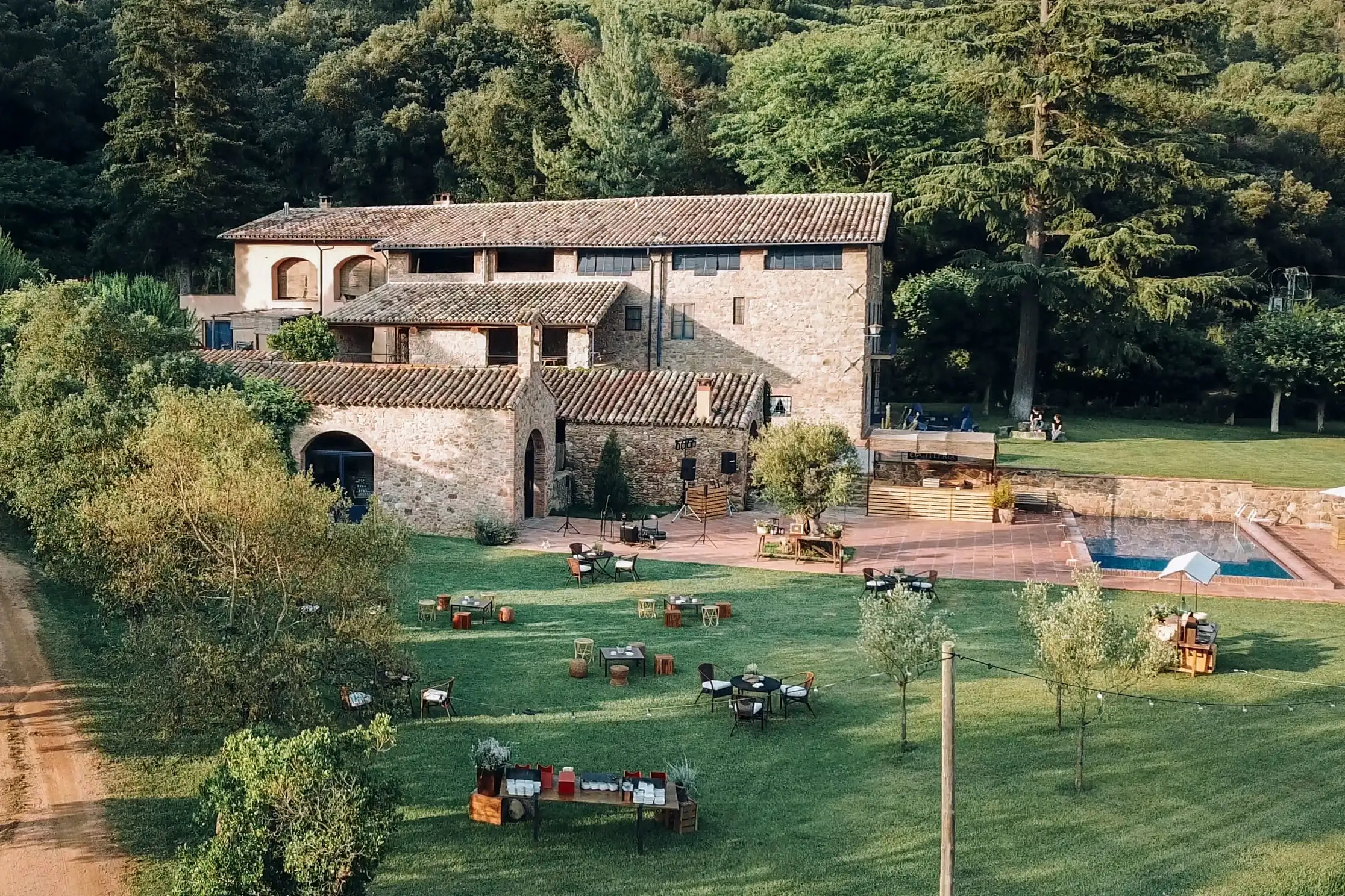 View from above of the stone farmhouse with tables and seating areas spread across the lawn