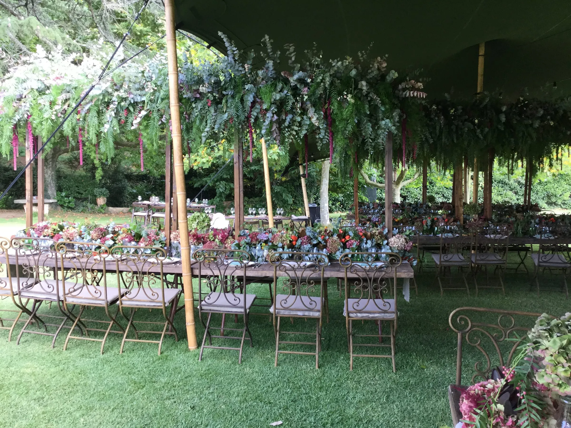 Placeholder image in place of a render: long tables under a marquee hung with garlands of flowers and eucalyptus